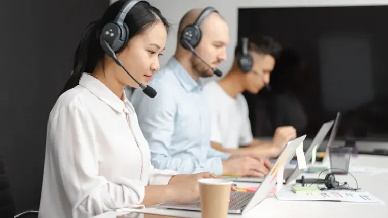 Small business customer support agent using an AI chatbot tool on a laptop
