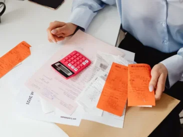 Small business owner reviewing receipts and calculating bookkeeping figures