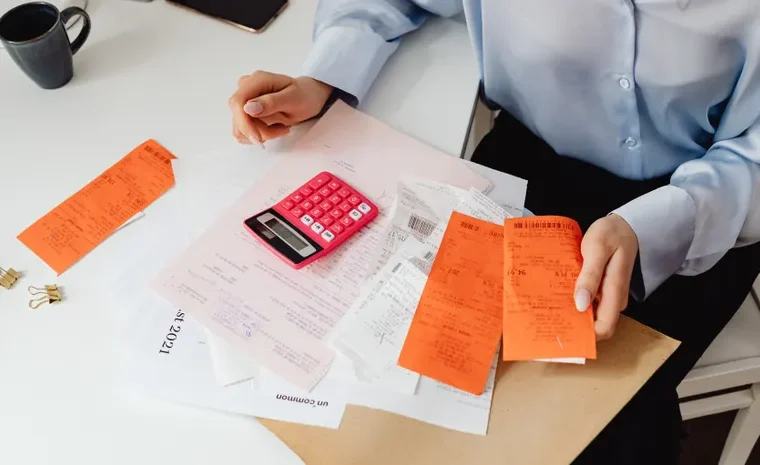 Small business owner reviewing receipts and calculating bookkeeping figures
