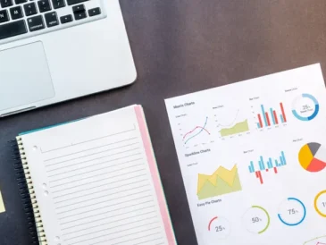 Laptop and data charts on a desk representing competitor research analysis