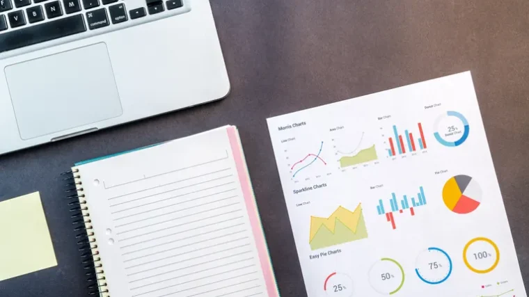 Laptop and data charts on a desk representing competitor research analysis