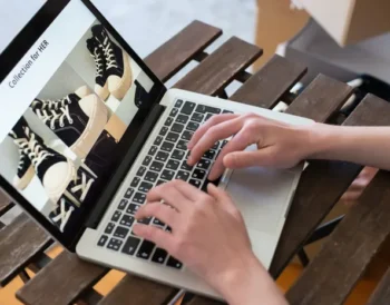 Person creating a fashion product collection on a laptop for an online store