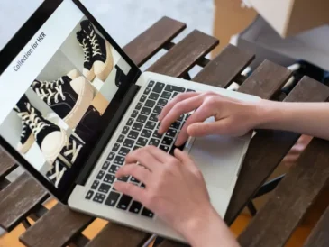 Person creating a fashion product collection on a laptop for an online store