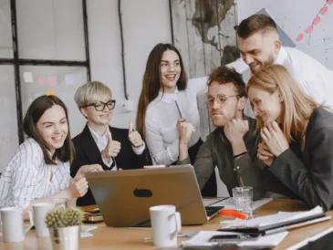 Small team in a meeting using a laptop for AI meeting transcription