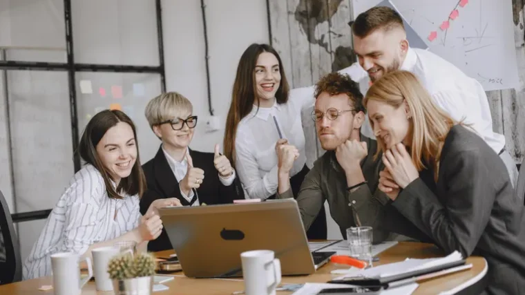 Small team in a meeting using a laptop for AI meeting transcription