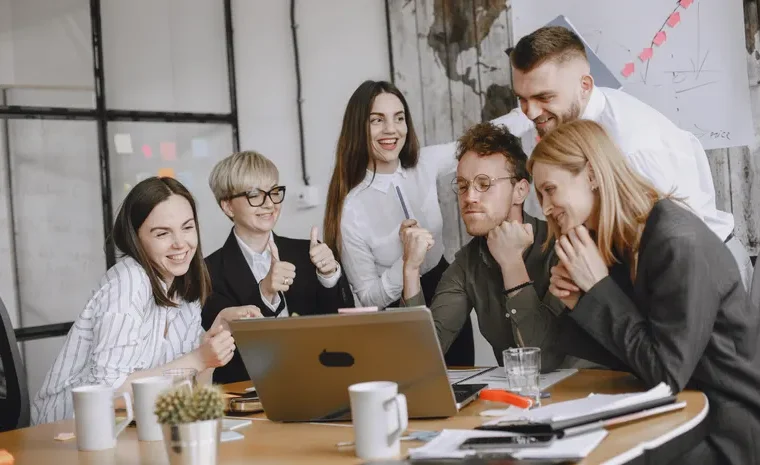 Small team in a meeting using a laptop for AI meeting transcription