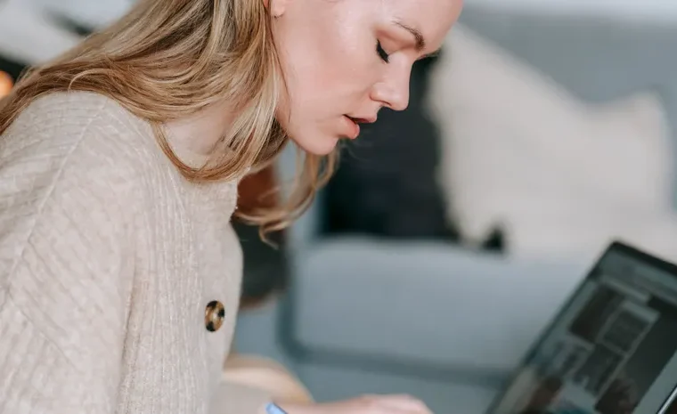 Student taking notes with a laptop for study and research