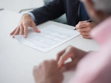 Two business professionals discussing documents, representing international business communication