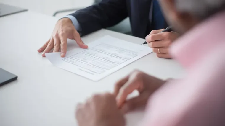 Two business professionals discussing documents, representing international business communication