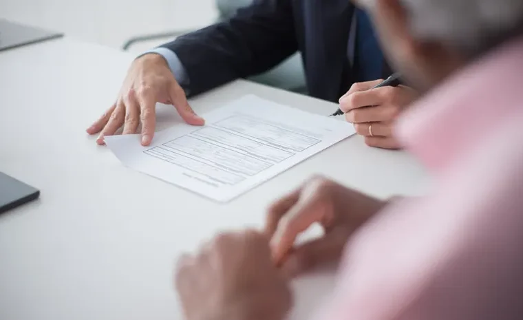 Two business professionals discussing documents, representing international business communication