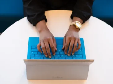 Person typing on a laptop keyboard managing account logins