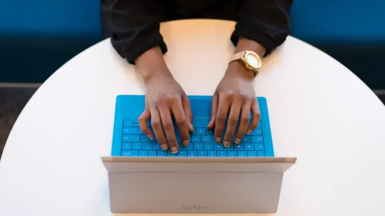 Person typing on a laptop keyboard managing account logins