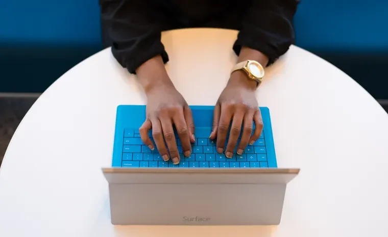 Person typing on a laptop keyboard managing account logins