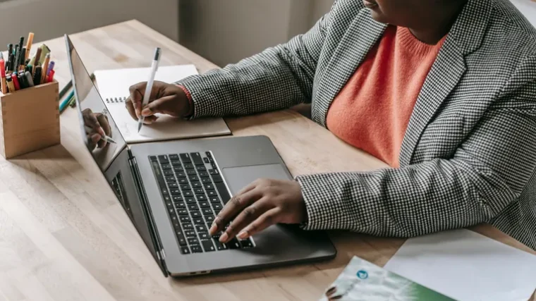 Person typing an email on a laptop using ChatGPT prompts