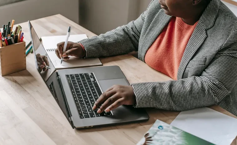 Person typing an email on a laptop using ChatGPT prompts