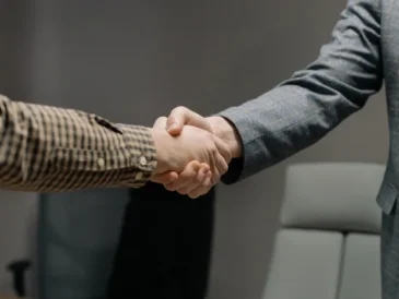Two people shaking hands, representing human trust and judgement AI cannot replace