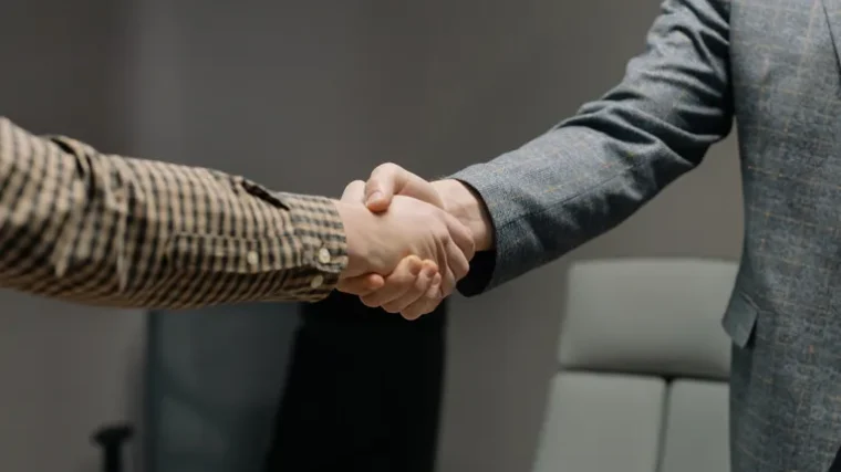 Two people shaking hands, representing human trust and judgement AI cannot replace