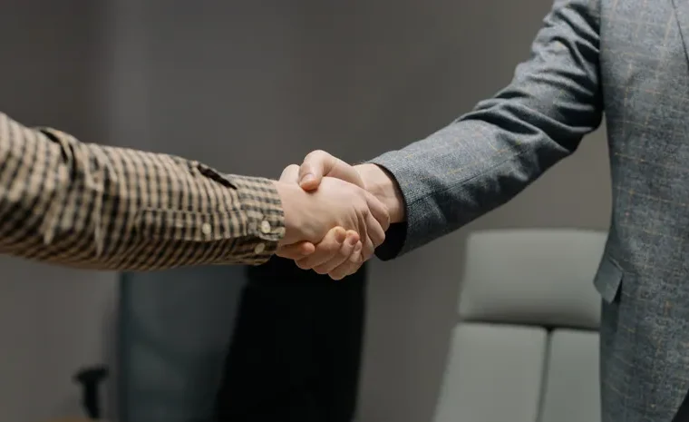 Two people shaking hands, representing human trust and judgement AI cannot replace